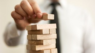 business man stacking jenga blocks