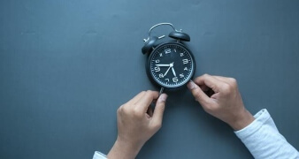 two hands holding a clock